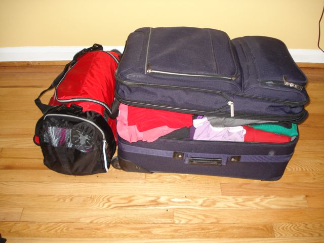 Red duffel bag and purple suitcase packed.