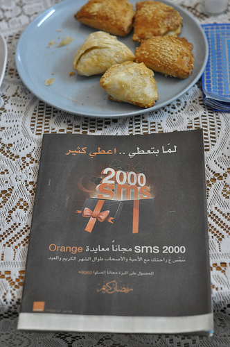 Plate of borekas and Arabic language cellphone ad for Orange.
