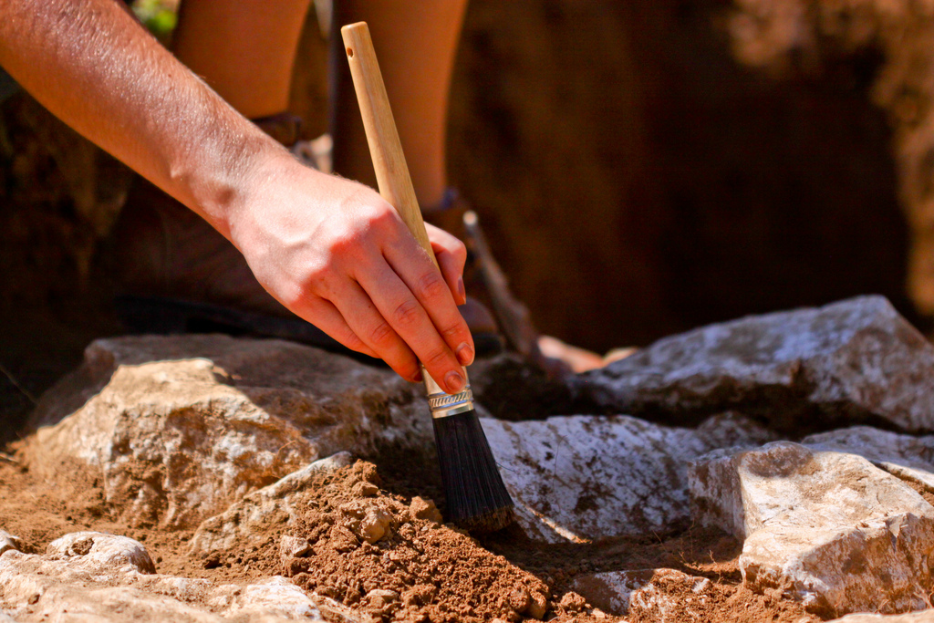 A brush carefully removes soil from artifacts at the Shaker Village of Pleasant Hill.