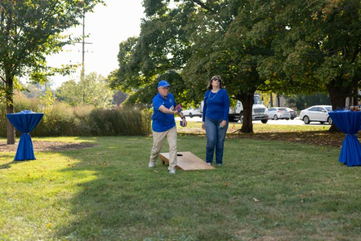 alumni playing cornhole game outside