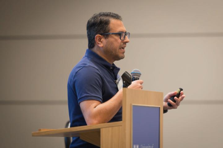 A speaker delivering a presentation from the stage.