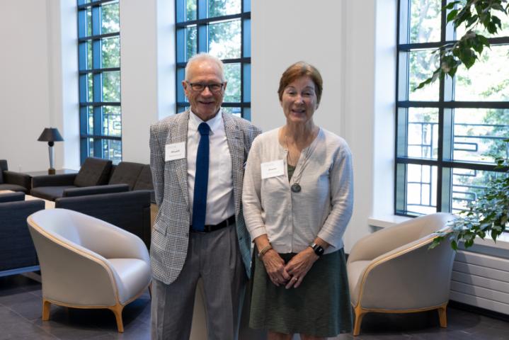 Couple smiling together in lobby with large windows.