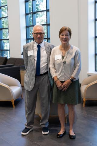 Couple posing side by side in bright event space.