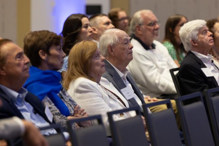 Audience members listening closely during presentation.