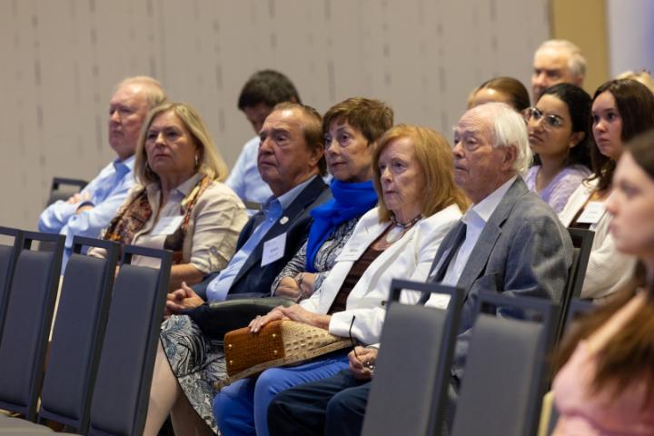 Group of attendees in front row paying close attention.