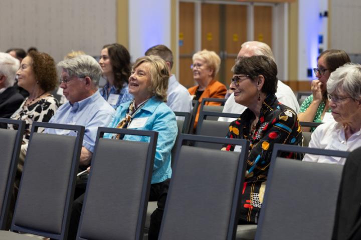 Group in front row smiling and enjoying presentation.