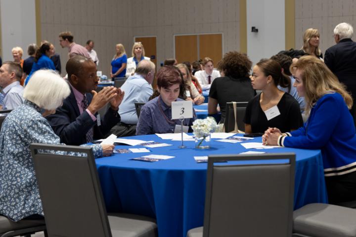 Group at round table in discussion during event session.