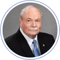 William "Bill" Schweri in a black suit jacket and blue tie