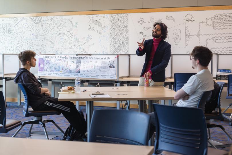 Shane D'Souza in front of students lecturing
