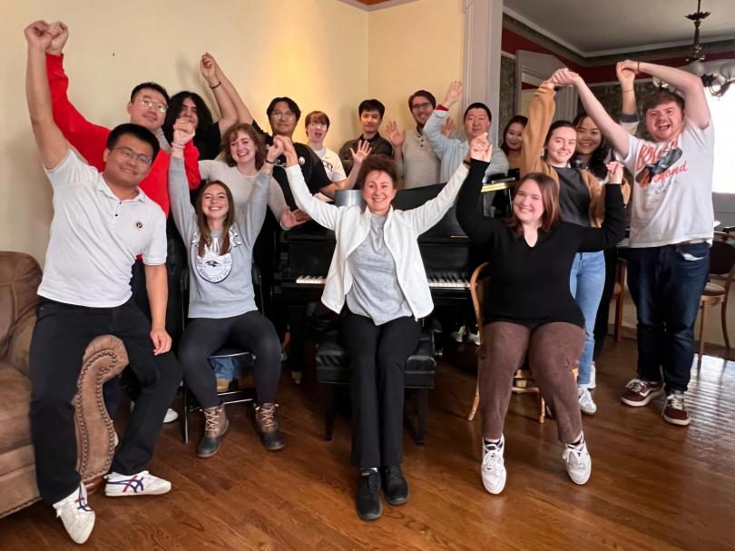 Photo of students around piano